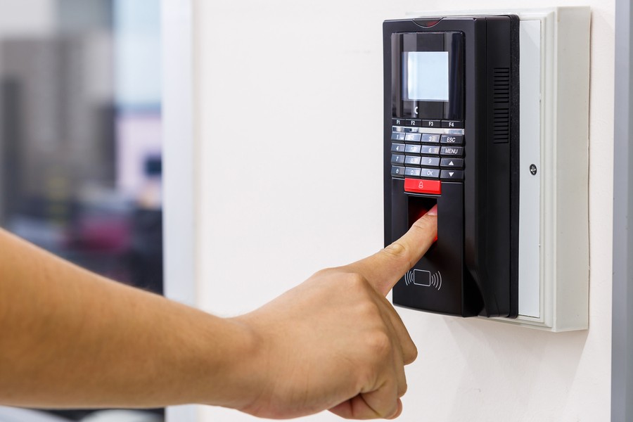 A person using the fingerprint reader at an access control point.