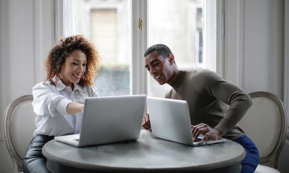 Araknis, woman pointing at laptop with man on laptop